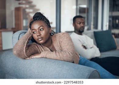 I dont want to hear anything he has to say. a young couple sitting on the sofa and giving each other the silent treatment after an argument.