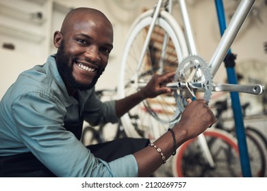 Dont worry Its such a tiny problem to fix. Shot of a handsome young man crouching in his shop and repairing a bicycle wheel. - Powered by Shutterstock