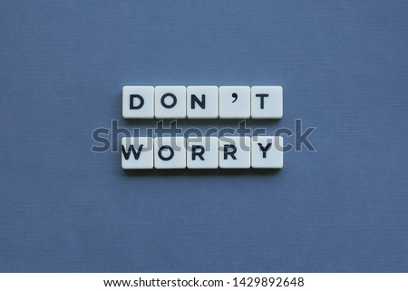 ' Don't Worry ' word made of square letter word on grey background.