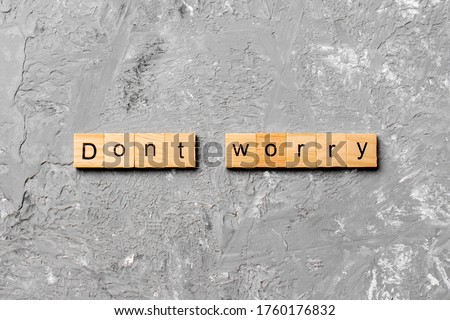 Don't worry word written on wood block. Don't worry text on cement table for your desing, Top view concept.