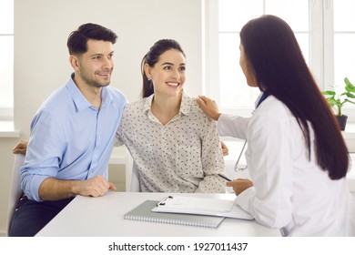 Don't Worry, You're In Good Hands. Doctor Touching Woman's Shoulder Reassuring Patients At Hospital. Happy Young Couple, Husband And Wife, Planning Pregnancy And Seeing Family Practitioner Together