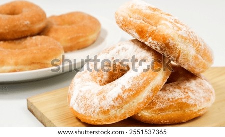 Donut Delight, A Stack of Freshly Baked Donuts on cutting wooden board and white plate isolated on white background