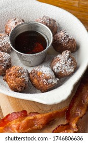 Donut Or Doughnut Holes, Deep Fried And Coated With Cinnamon, Powdered Sugar And Served With Vermont Maple Syrup And Crispy Bacon. Classic American Restaurant Breakfast Or Brunch Favorite.