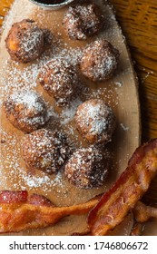 Donut Or Doughnut Holes, Deep Fried And Coated With Cinnamon, Powdered Sugar And Served With Vermont Maple Syrup And Crispy Bacon. Classic American Restaurant Breakfast Or Brunch Favorite.