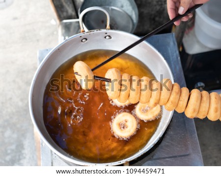Donut fried maker making machine with stainless steel mold optional, frying sweet and tasty donuts on hot oil in a pan