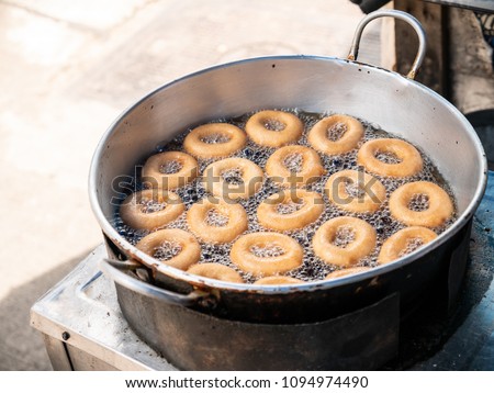 Donut fried maker making machine with stainless steel mold optional, frying sweet and tasty donuts on hot oil in a pan