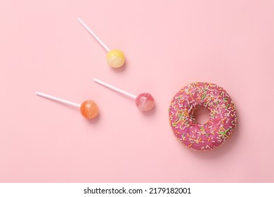 Donut lollipop on pink background. Allegory of fertilization of the egg. top view
