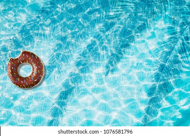 Donut Pool Float, Ring Floating In A Refreshing Blue Swimming Pool
