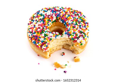 a donut with sprinkles with one bite taken out of it isolated on white