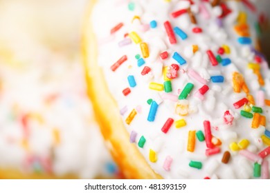 Donut with sprinkles and white iced. Donuts background. Cake and sweet. Food detail. Close up - Powered by Shutterstock