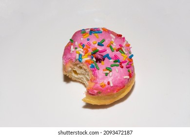 Donut With Strawberry Icing And Colored Sprinkles With Bite Mark. Home-made Sweet Donut.