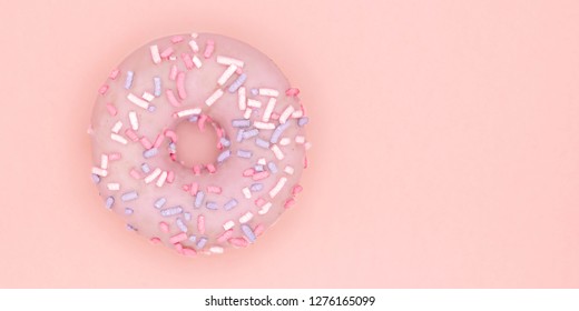 Donut sweet dessert with colorful sprinkles flat lay on pastel coral paper background. Doughnut minimal concept. Copy space.