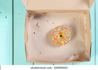 Donuts In Box On Wooden Table. Top View