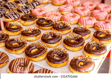donuts with chocolate frosted, pink glazed and sprinkles donuts.