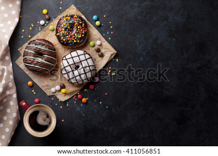 Donuts and coffee on stone table. Top view with copy space