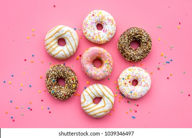 Donuts decorated icing and sprinkles on pink background top view pattern - Powered by Shutterstock