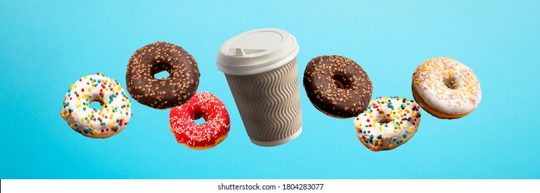 Donuts Flying In The Air And Coffee Paper Cup On A Blue Background. Bakery, Baking Concept. Levitation. Banner