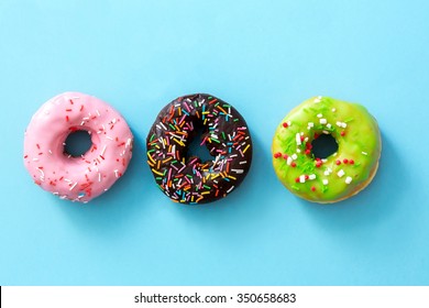 Donuts glazed with sprinkles on a blue background