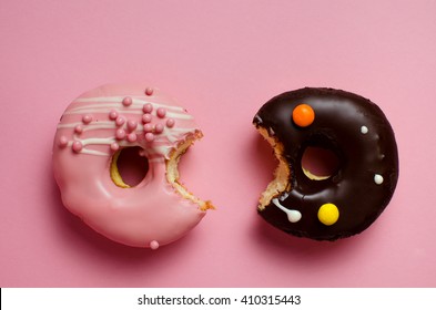 Donuts with icing on pink background. Sweet donuts. Donuts background . Eaten donut.