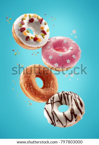 Donuts selection flying on blue background. Various doughnuts isolated on colorful background