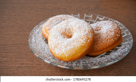 Donuts sprinkled with powdered sugar on a plate - Shutterstock ID 1780695278