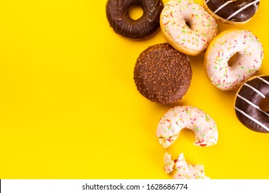 Donuts with various toppings on yellow background. Fat Thursday. Doughnuts