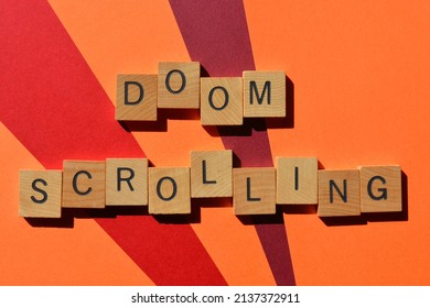 Doom Scrolling, words in wooden alphabet letters isolated on red and orange background