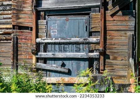 the door of an abandoned house is boarded up with boards