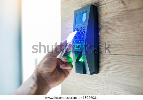 Door access control. Staff holding a key card to\
lock and unlock door at home or condominium. using electronic card\
key for access. electronic key and finger scan access control\
system to unlock doors