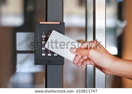 Door access control - young woman holding a key card to lock and unlock door.