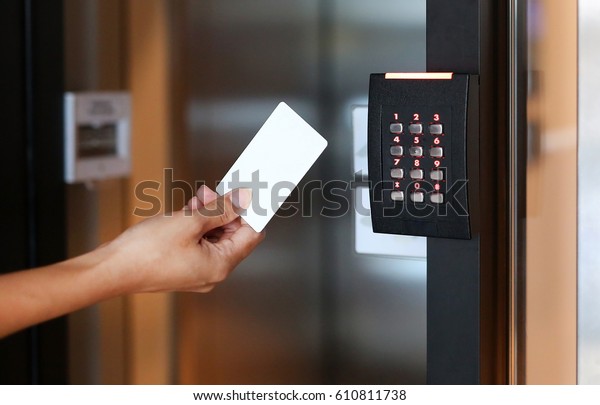 Door access control - young woman holding a key\
card to lock and unlock\
door.