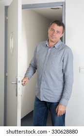 At the door in a bright modern office a man  waiting for someone