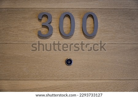  Door camera with room numbers on wood door background.                              