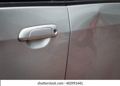 Door car with damage on accident with dent on left side on raining day