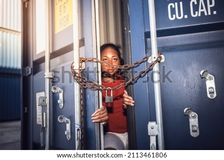 The door of a container which was covered with iron chains and keys, inside of which several African woman sitting inside, to human trafficking and illegal immigration concept.