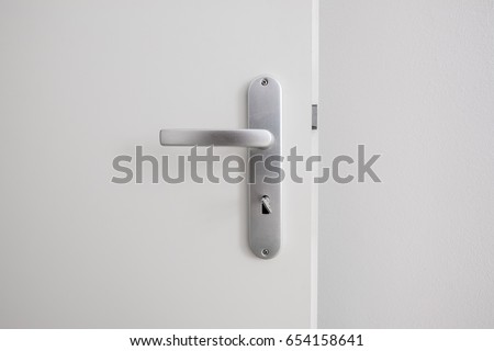  door handle with key on white door closeup