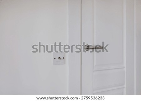 door handle and light switch next to it in a bright room or office