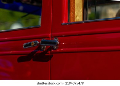 the door handle of an old red old-timer car