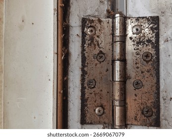 a door hinge that is rusty and has a lot of dust stuck around it