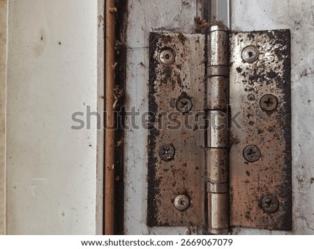a door hinge that is rusty and has a lot of dust stuck around it