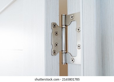 Door hinges cut into the wooden door, chrome interior details, connecting fastening screwed on screws, construction part. High quality photo