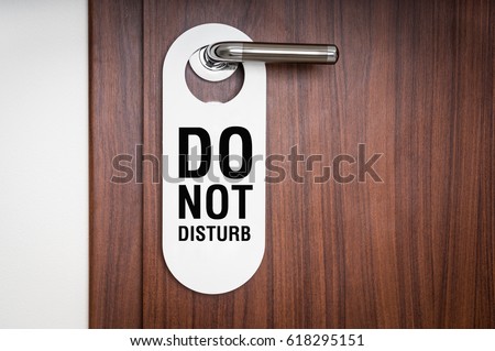 Door of hotel room with sign please do not disturb