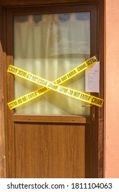 
Door Of A House Sealed With The Police Tape Not To Go Beyond And The Property Seizure Sheet