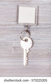 Door Key With White Blank Keychain On Wood Board