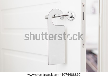 Door knob with empty label on a door handle for your text. Empty white flyer mockup hang on door handle. Leaflet design on entrance doorknob. Dont disturb sign. Hotel room clear hanger. blank