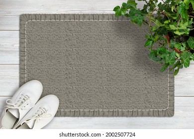 Door Mat Mockup. Mat On Wooden Floor, Ivy Flower In Pot And Shoes. Top View. Mockup For Text Or Design