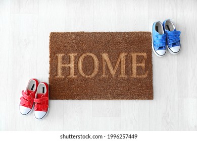 Door Mat With Shoes On Wooden Floor