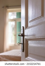 Door Open, Blur Elegant Hotel Room Or House Bedroom Interior, Window And Bed. Retro Door Knob On White Vintage Wooden Door, Close Up View.