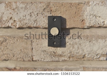 Doorbell, brick wall background.