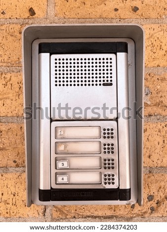 Doorbell intercom on brick wall